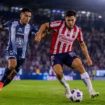 Imagen ilustrativa de futbolistas con uniformes inspirados en Pachuca y Chivas disputando el balón