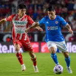 Imagen ilustrativa de futbolistas con uniformes inspirados en Necaxa y Cruz Azul disputando el balón