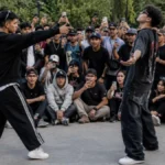Imagen ilustrativa de jóvenes realizando una batalla de aura frente a un grupo de espectadores