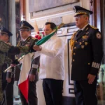 Joaquín Díaz Mena recibe la Bandera Nacional durante la ceremonia del Grito de Independencia en Yucatán